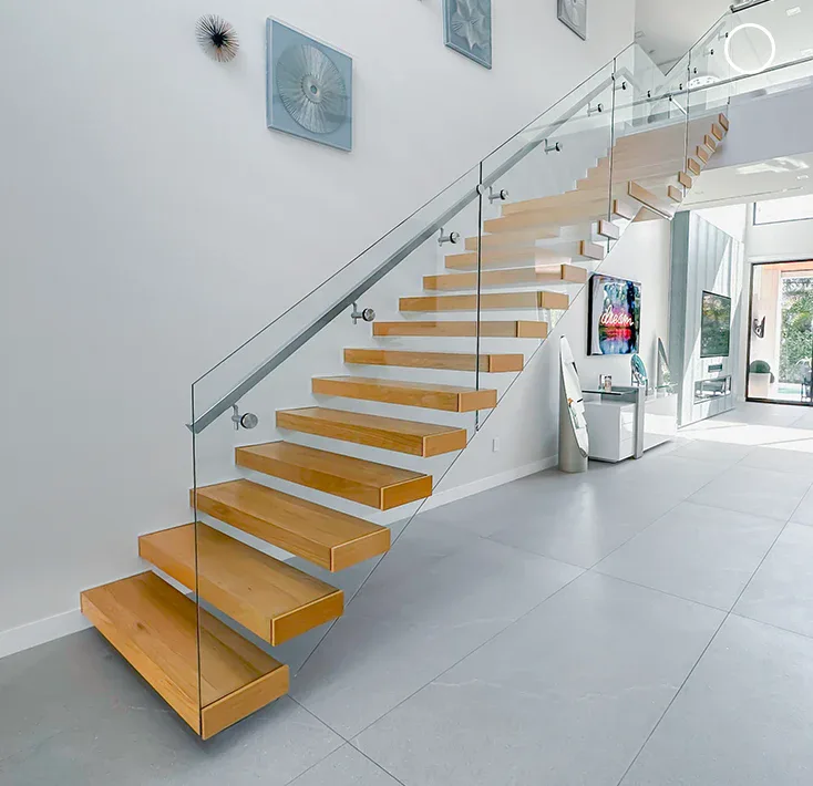 Stylish glass staircase with wooden steps and minimalist glass railing for contemporary interiors.