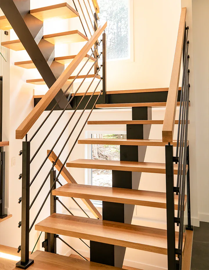 Elegant crystal glass and mirror staircase with modern black metal accents for stylish interior design.