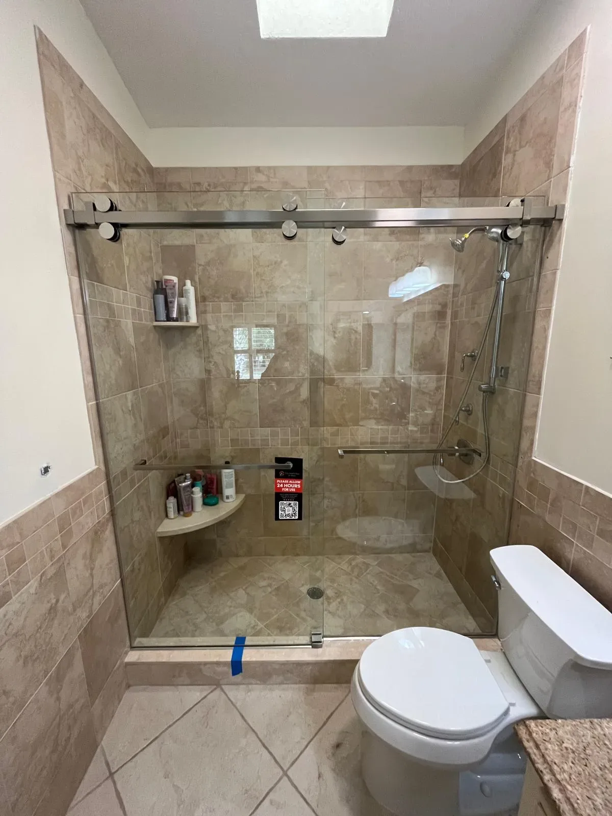 Durable glass shower door with sleek metal tracks, spacious tiled shower area, and modern bathroom fixtures.