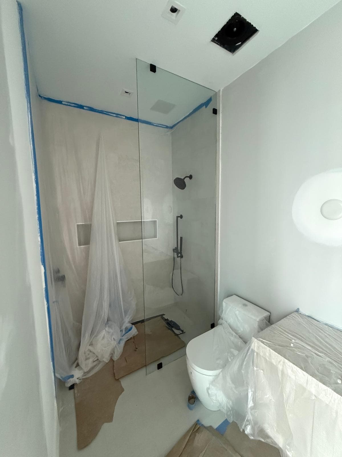 High-quality glass shower door with modern black fixtures, seamless design for luxury bathrooms.