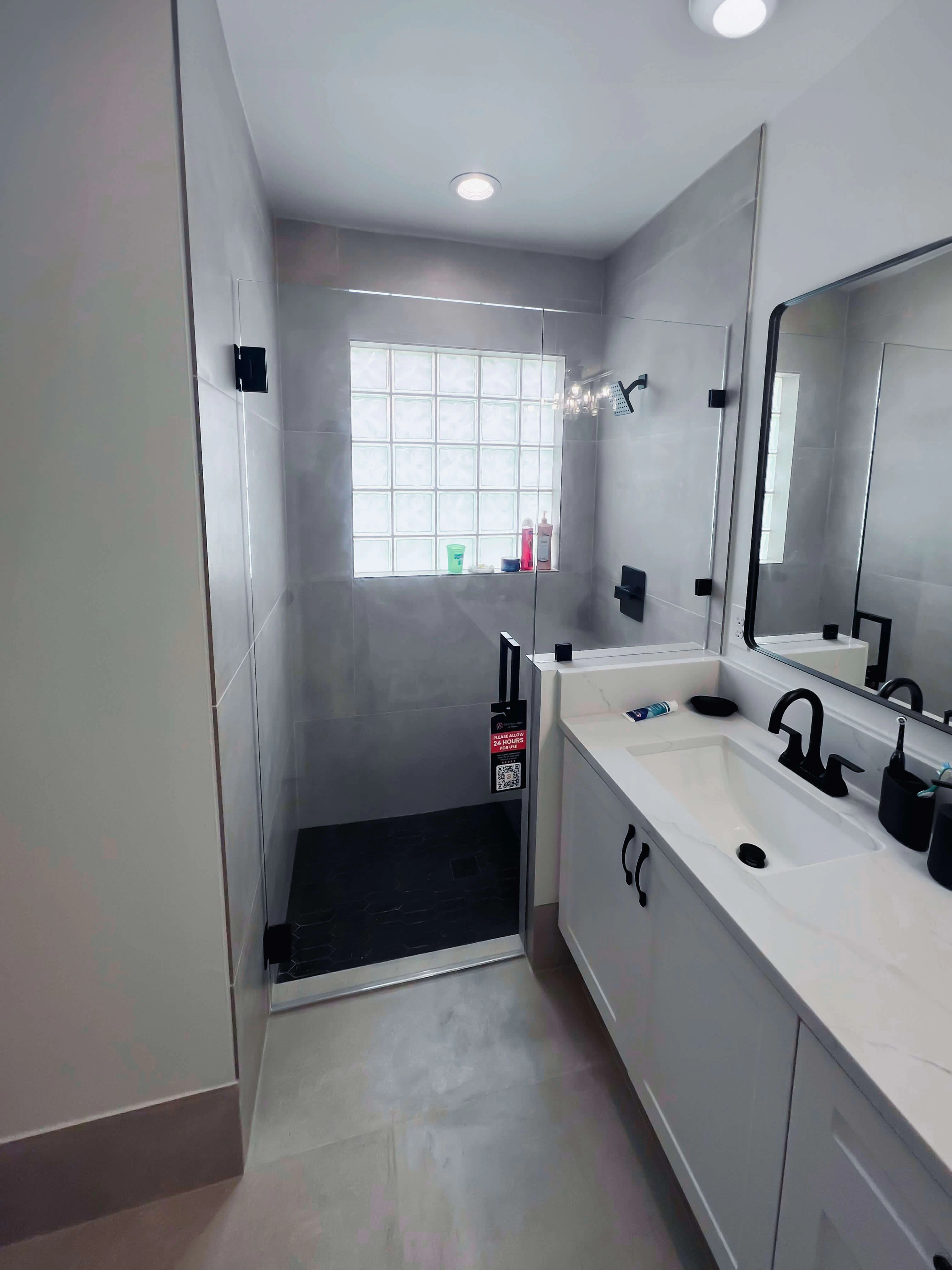 High-quality glass shower enclosure with modern black hardware.