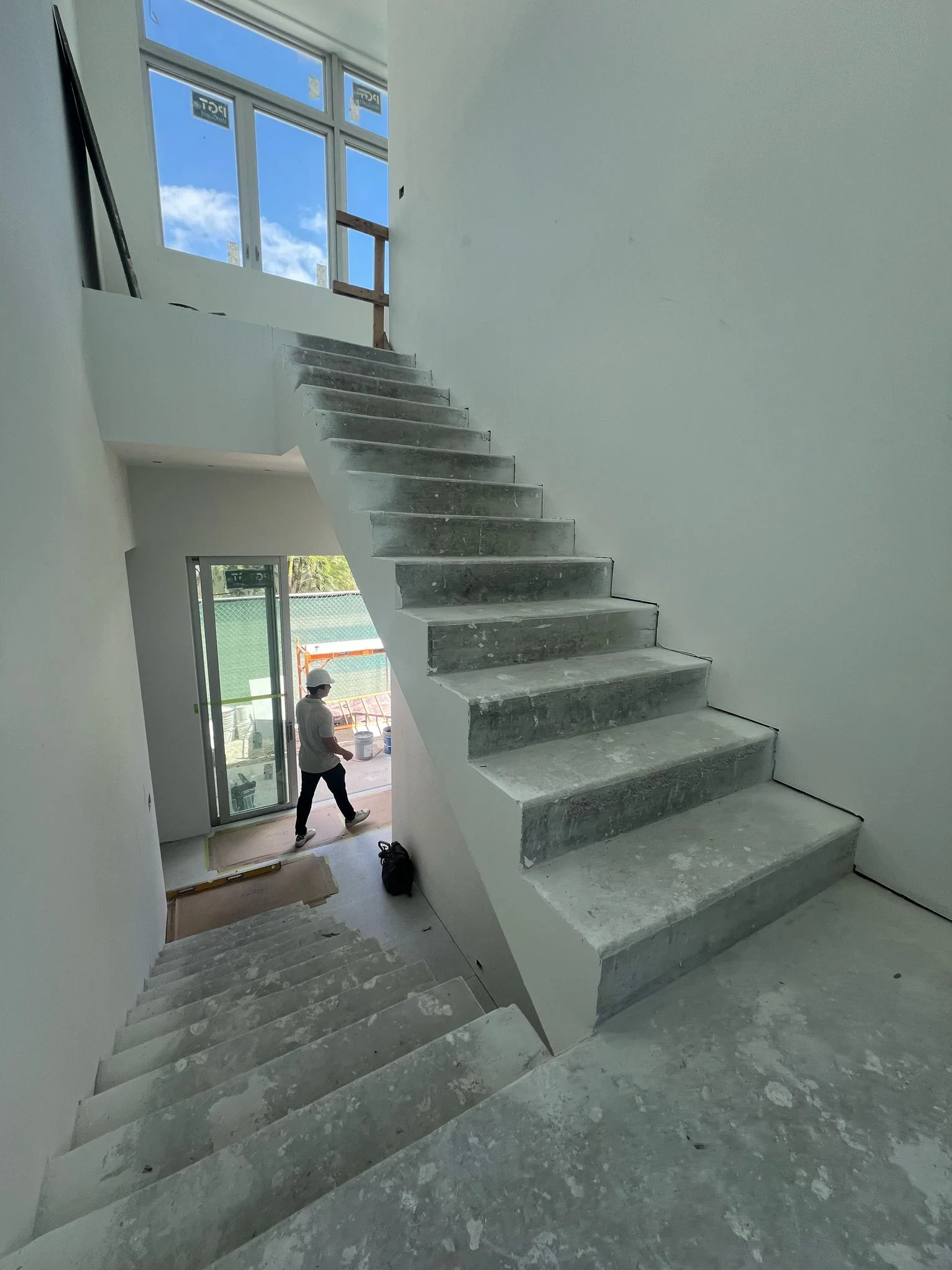 High-quality glass staircase in a modern home under construction, showcasing sleek design and clear glass panels.