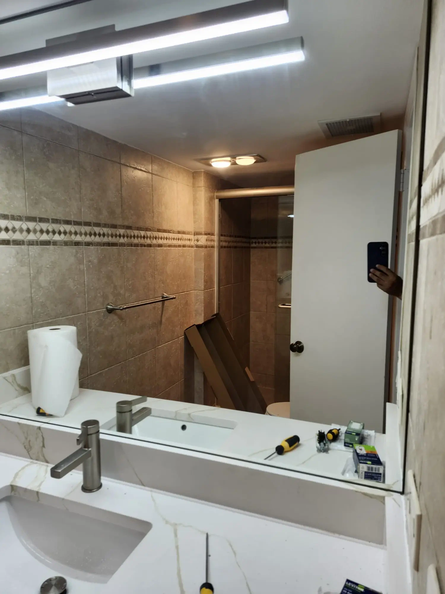 Bright bathroom with custom glass and mirror installation.