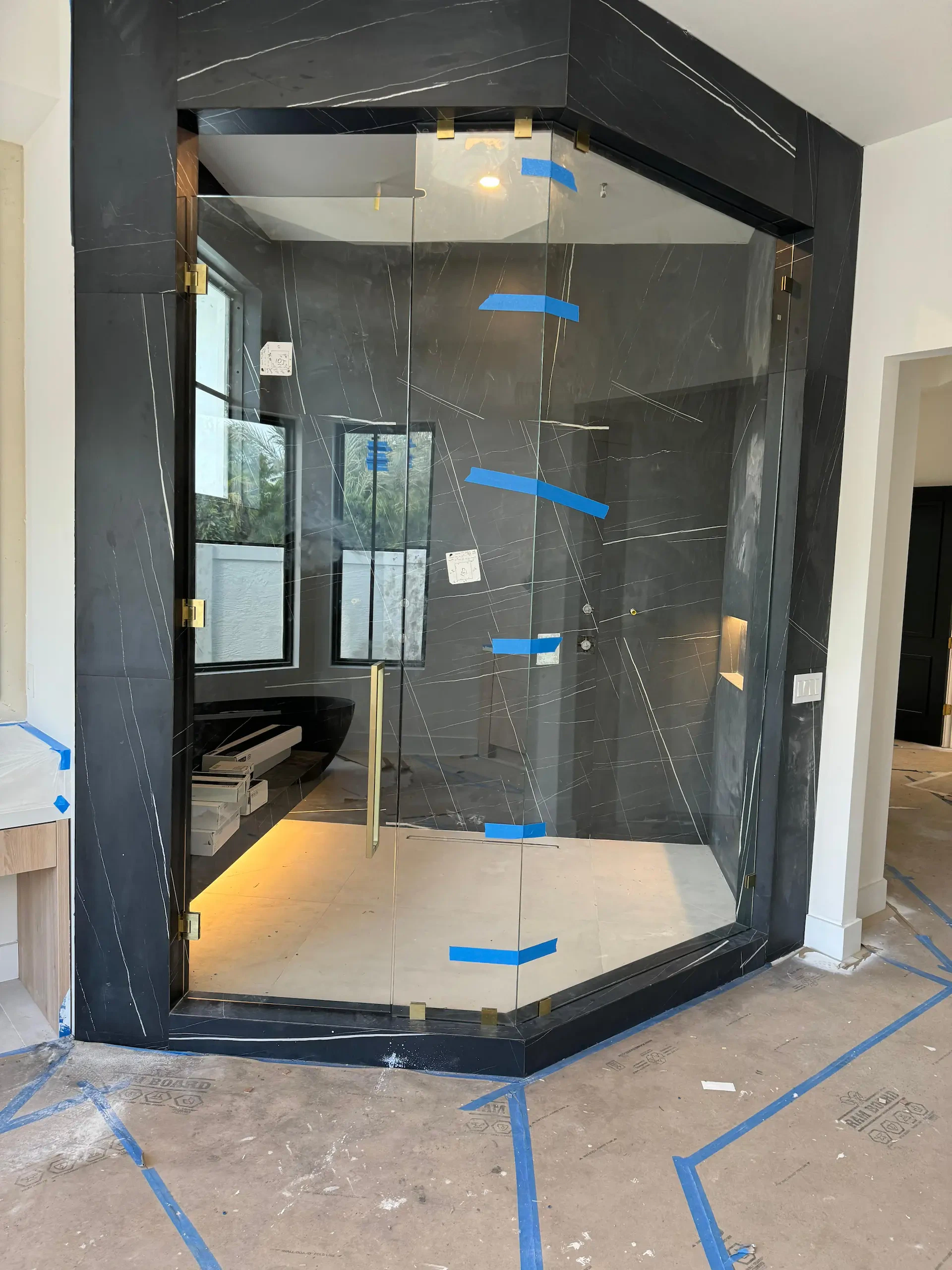 High-quality black marble glass shower door with modern design and gold hardware. Perfect for luxury bathrooms.