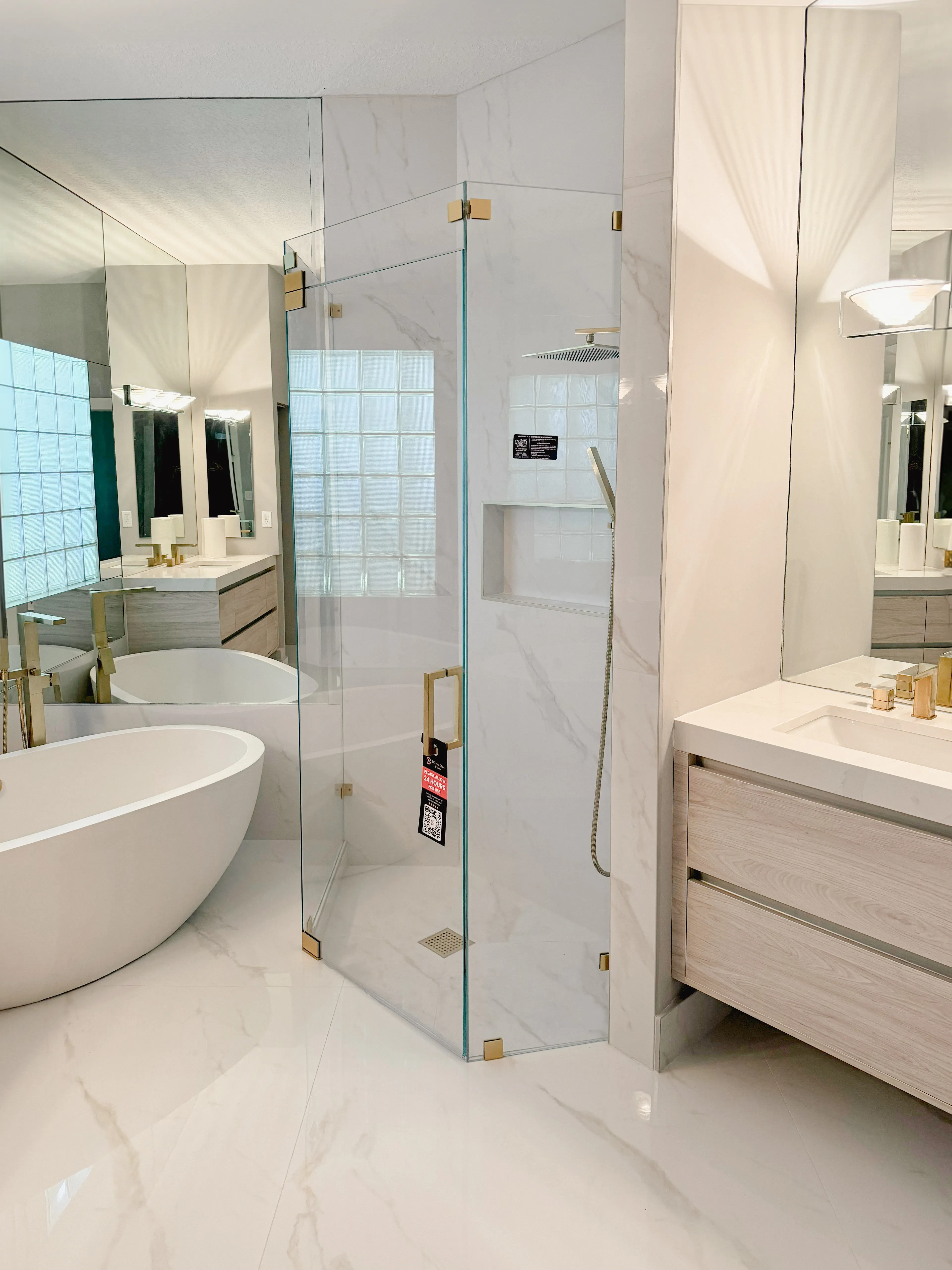 Beautiful modern glass shower with sleek, frameless design and brass hardware.