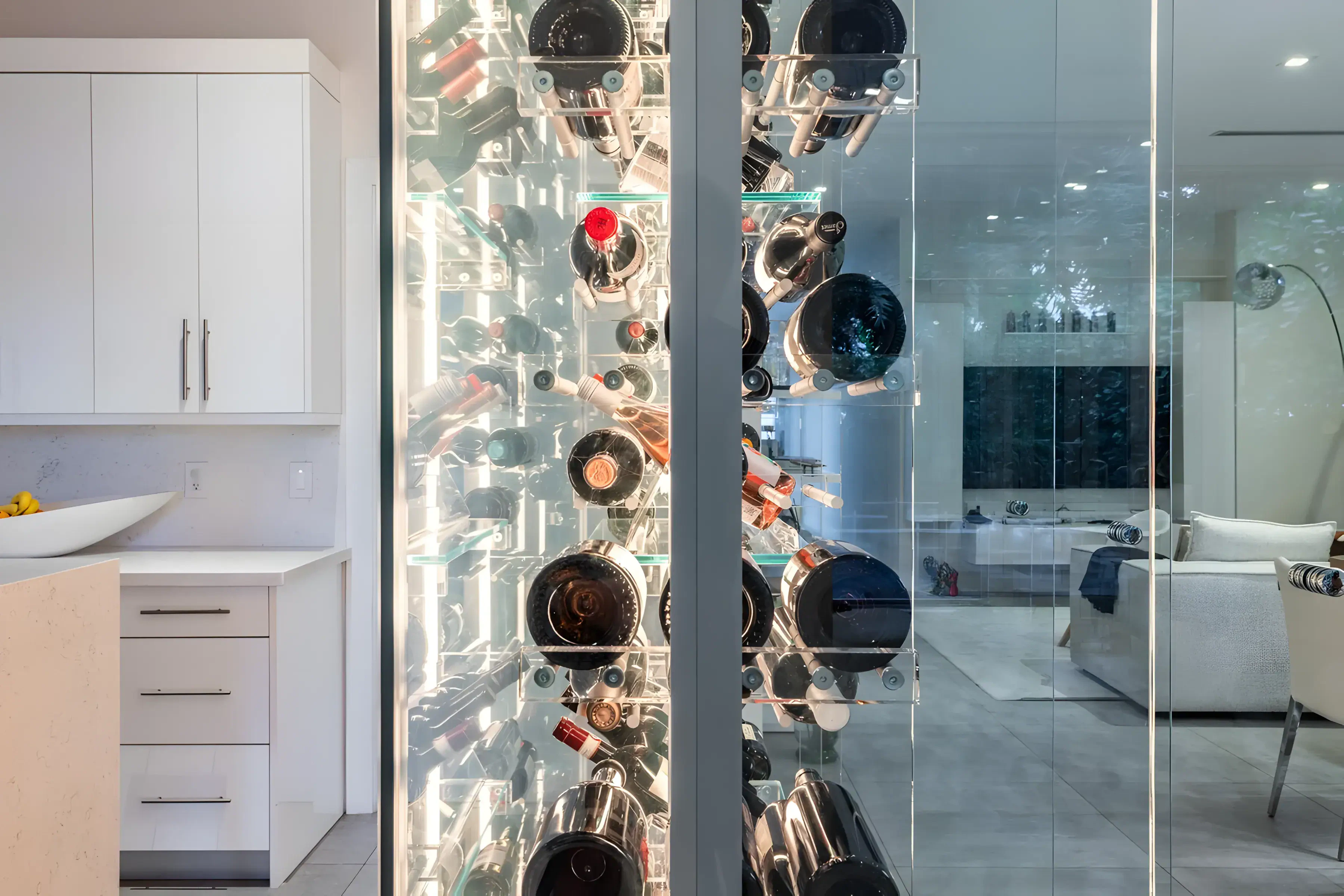 Highly reflective glass wine storage display with sleek cabinetry and contemporary décor.