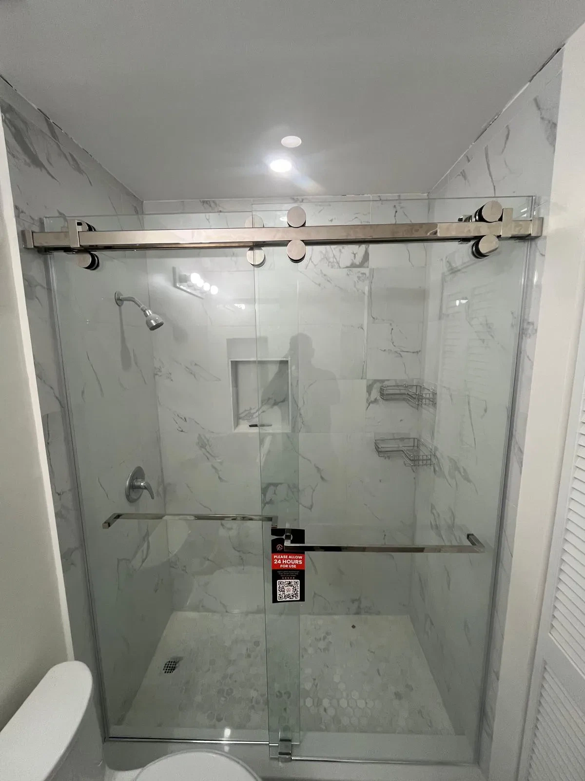 Elegant glass shower with brushed metal sliding door. Modern, durable, and stylish bathroom upgrade.