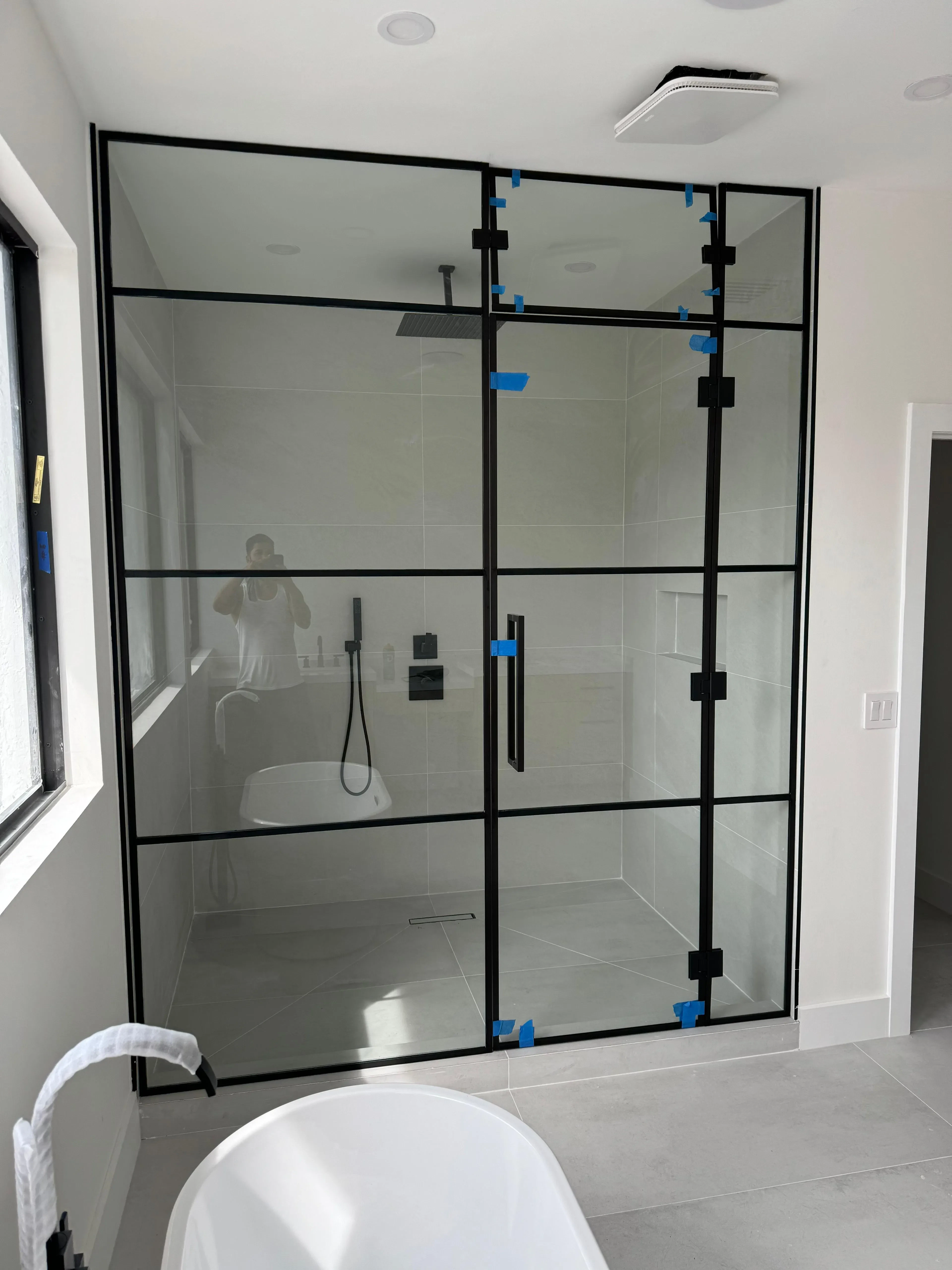High-quality glass shower door with black metal frame, modern and stylish bathroom upgrade.