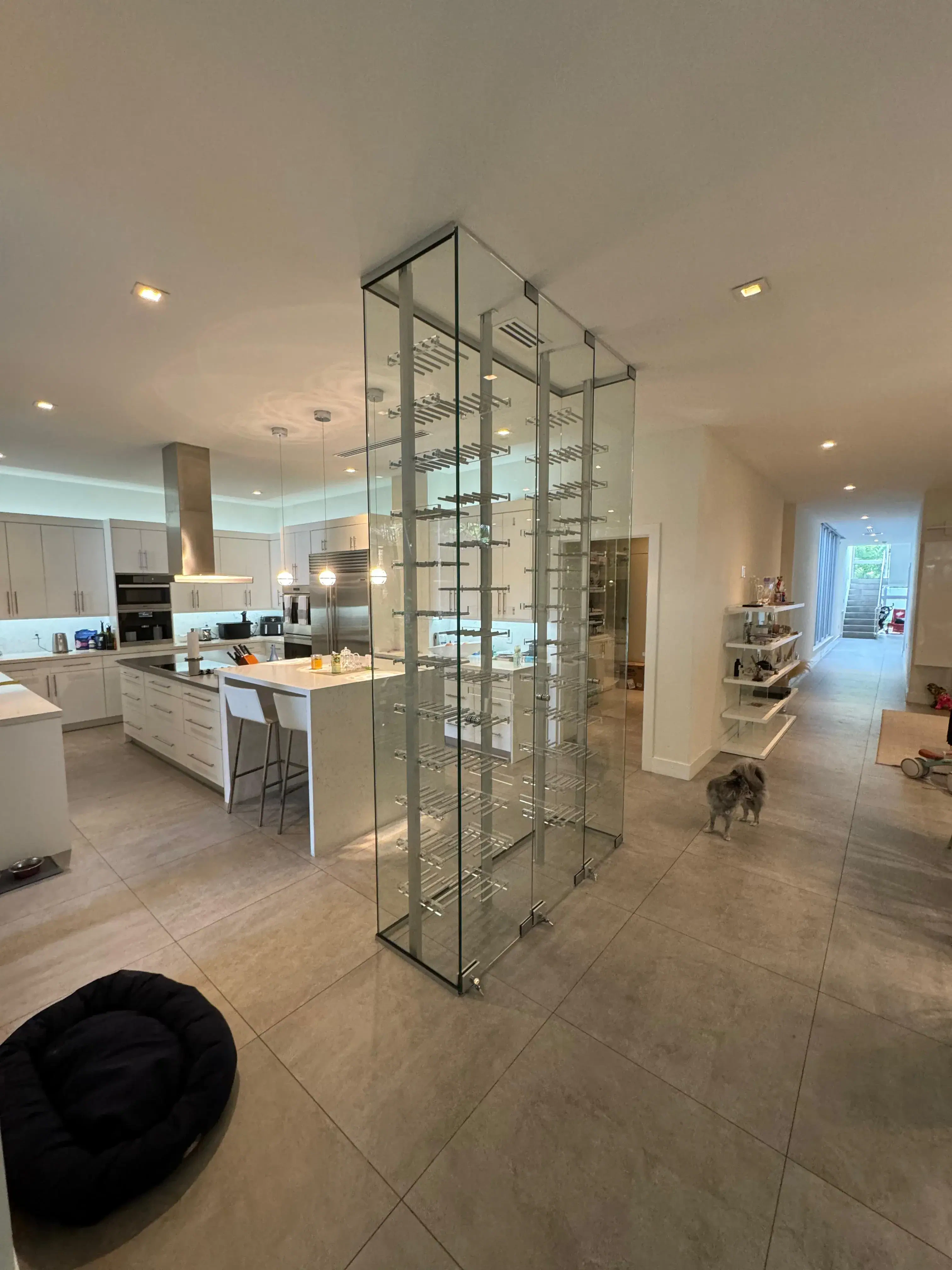 High-end transparent glass wine rack enclosure in modern kitchen décor.