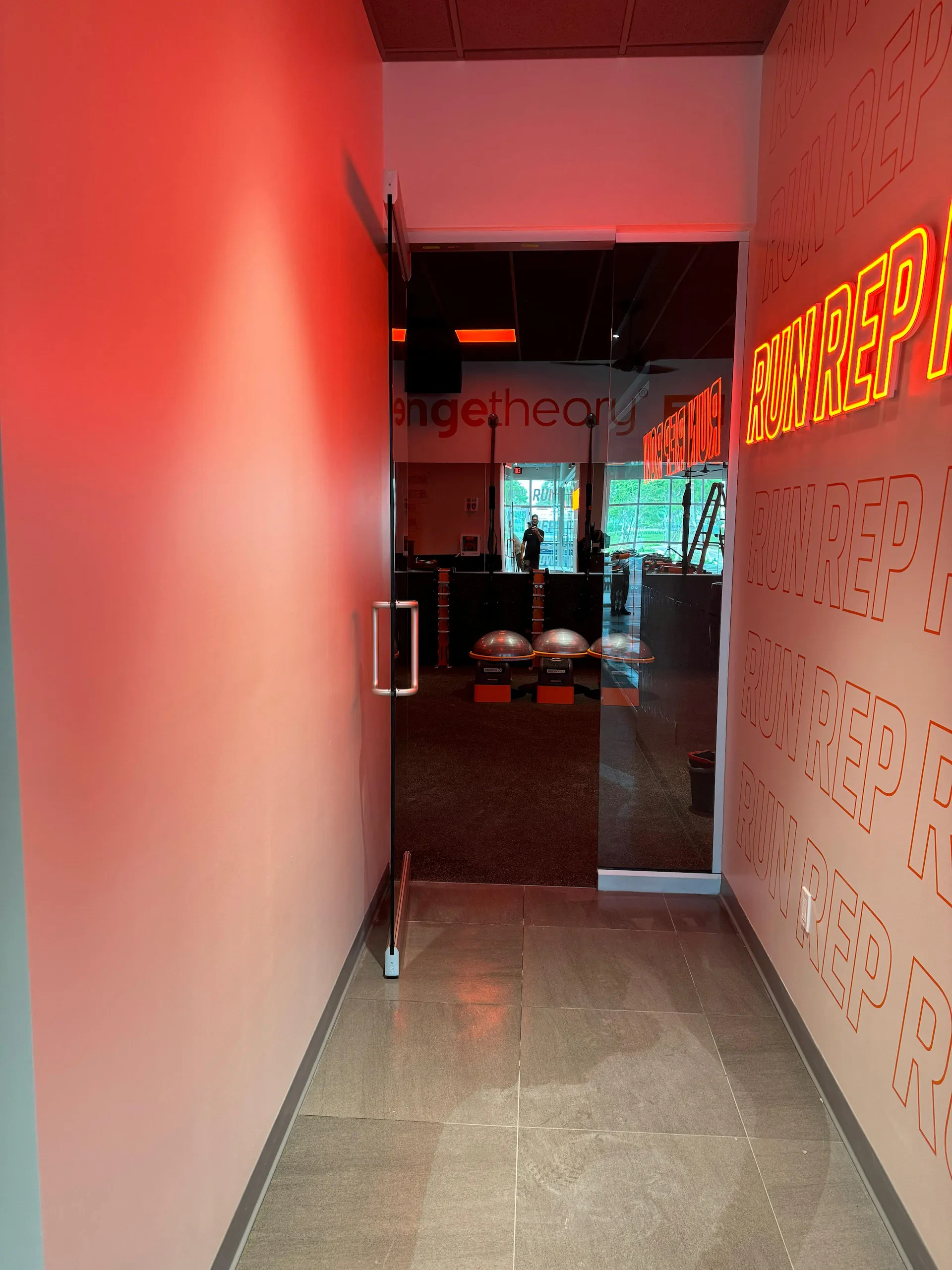 Reflective glass door at fitness studio entryway, modern design with fitness branding.