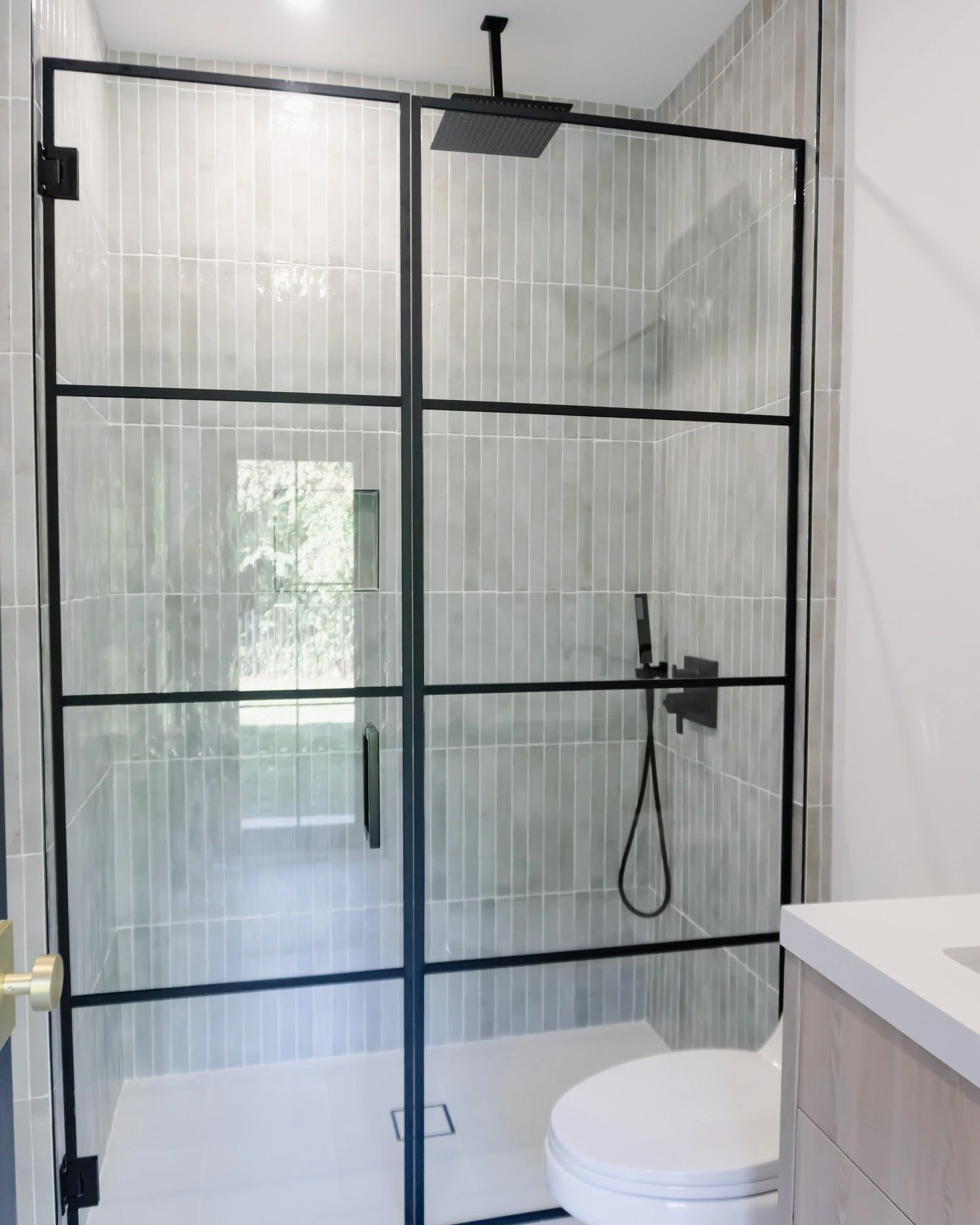 Elegant glass shower door with black framing and sleek fixtures for contemporary bathrooms.