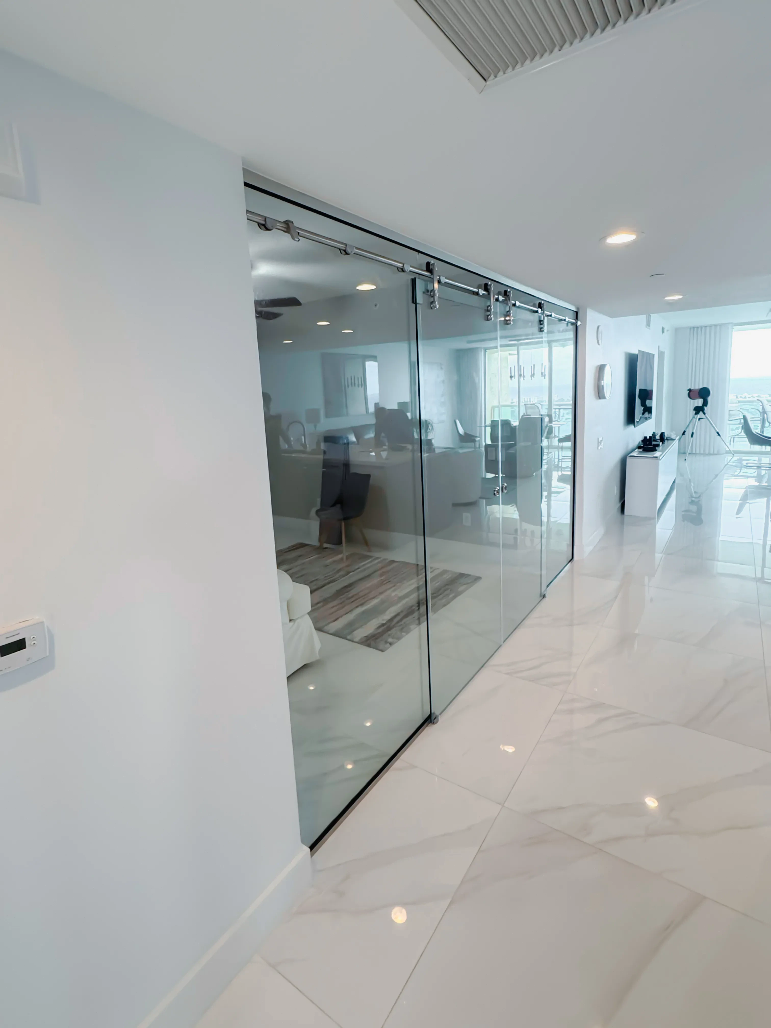 Transparent glass sliding door with metal hardware in contemporary living space.