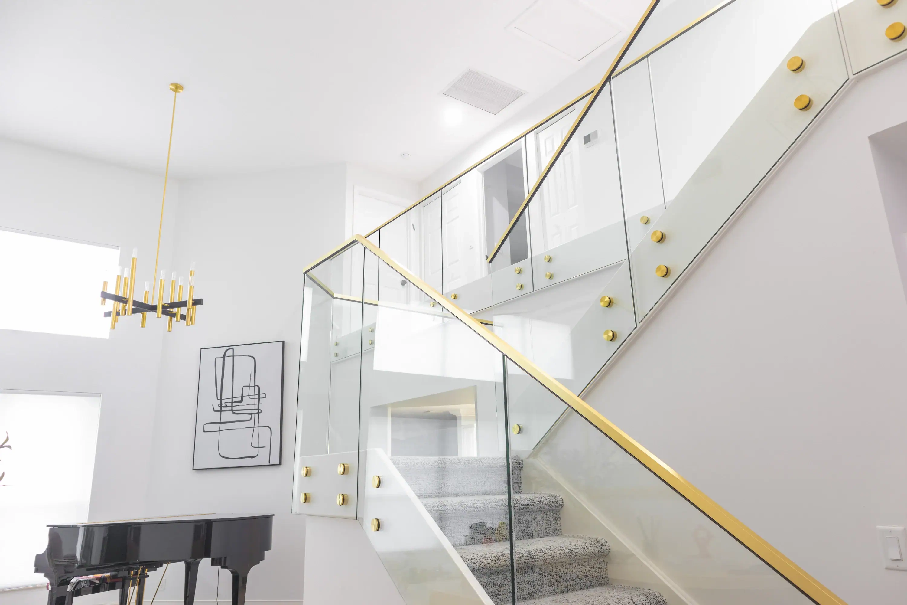 Stunning glass and mirror staircase with sleek gold accents in a contemporary home interior.