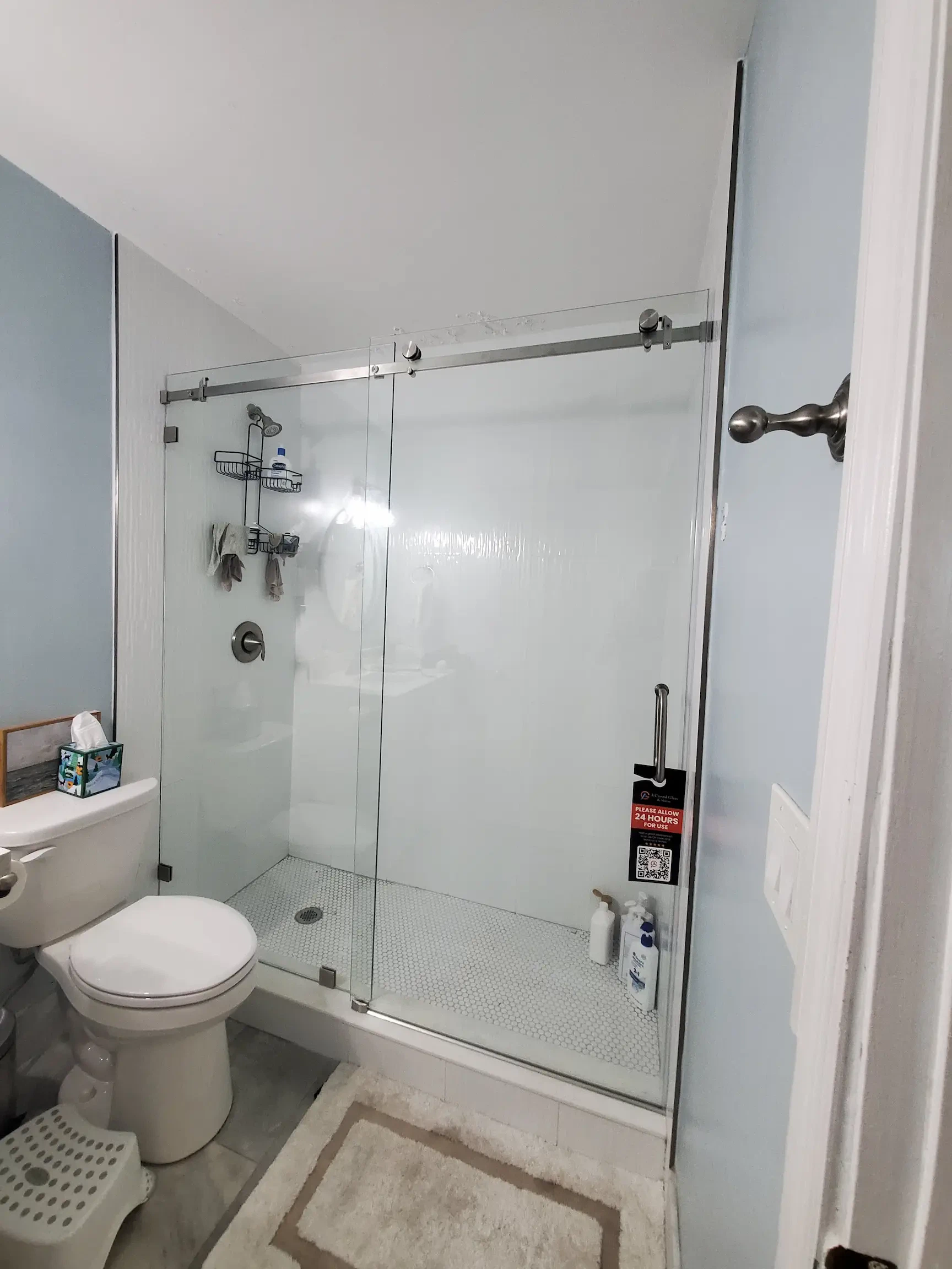 Clear glass shower door with sleek chrome hardware in bathroom fixture.