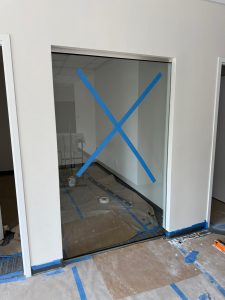 Modern glass wall with blue tape for installation.