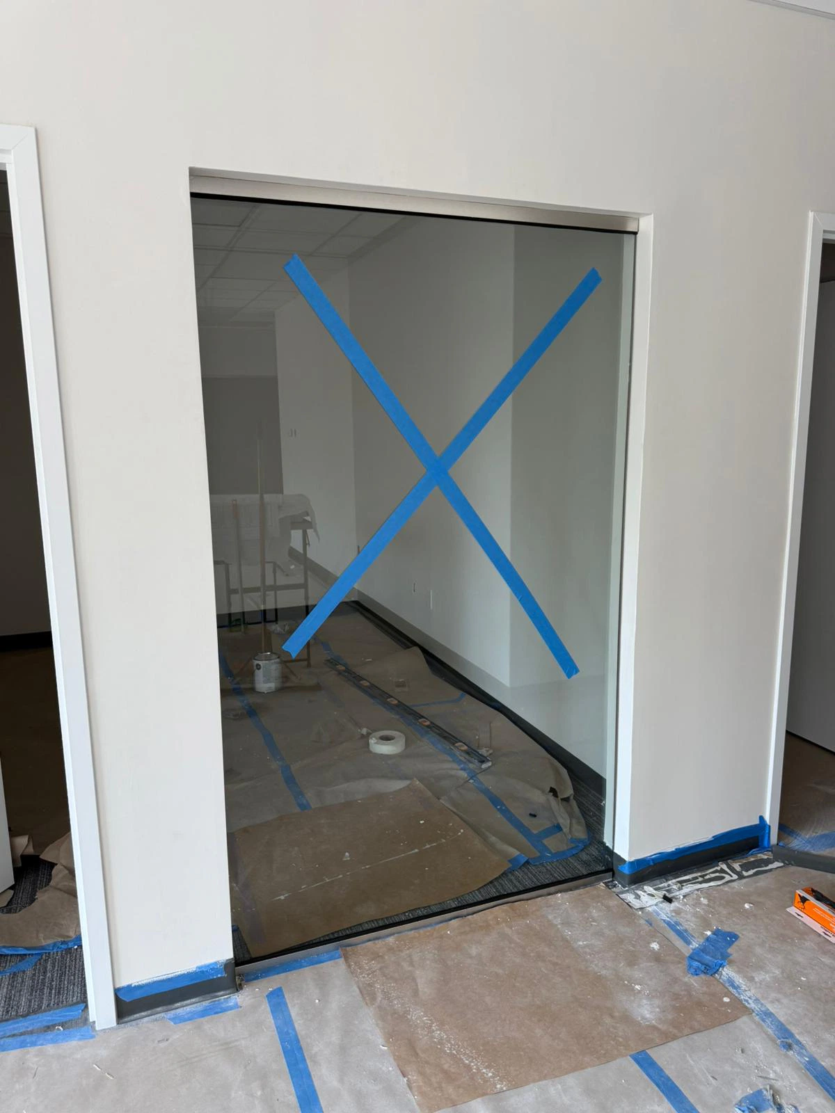 Modern glass wall with blue tape for installation.