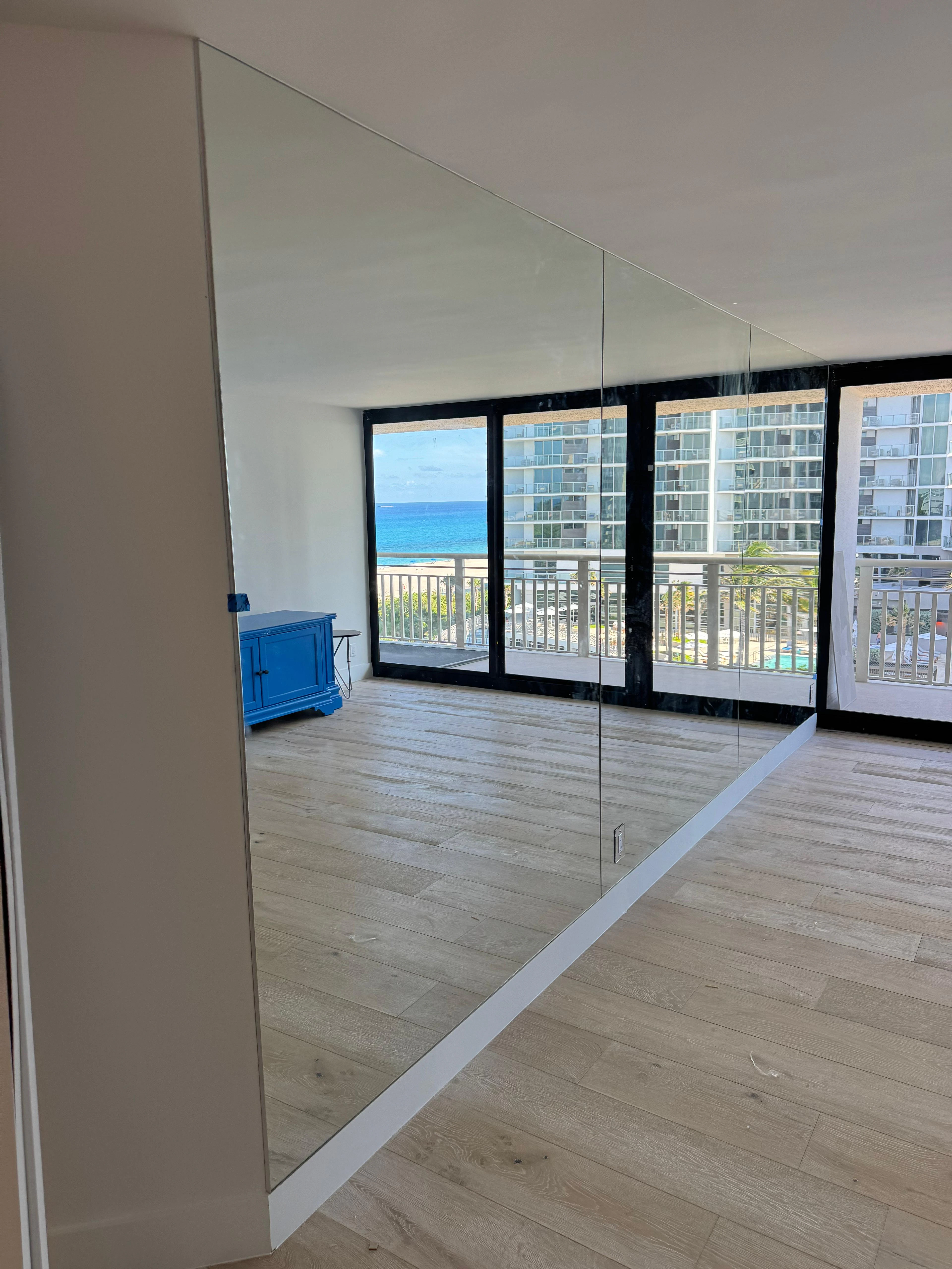 High-quality glass mirror installation for modern interiors with ocean views.