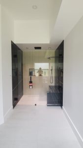 High-quality glass shower and mirror installation in modern bathroom design.
