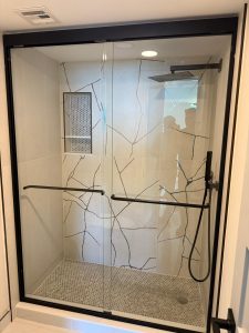 High-quality custom glass shower doors with black hardware, rain shower head, and modern design.