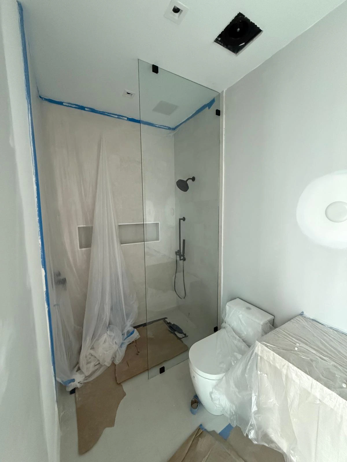 High-quality glass shower door with modern black fixtures, seamless design for luxury bathrooms.