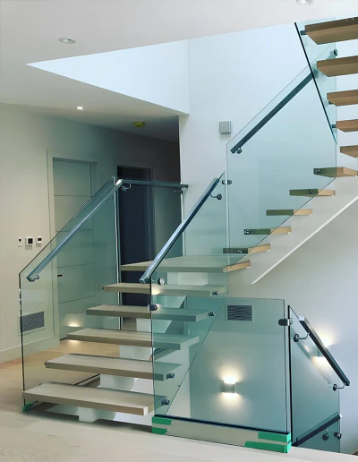 Stunning glass staircase with sleek metal and wood design in contemporary interiors.
