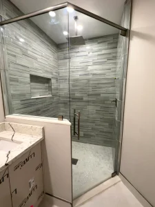 Premium glass shower enclosure with modern gray tile design. Durable, sleek, custom-made for luxury bathrooms.