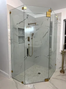 High-quality crystal glass shower with matte gold accents in luxurious bathroom setting.