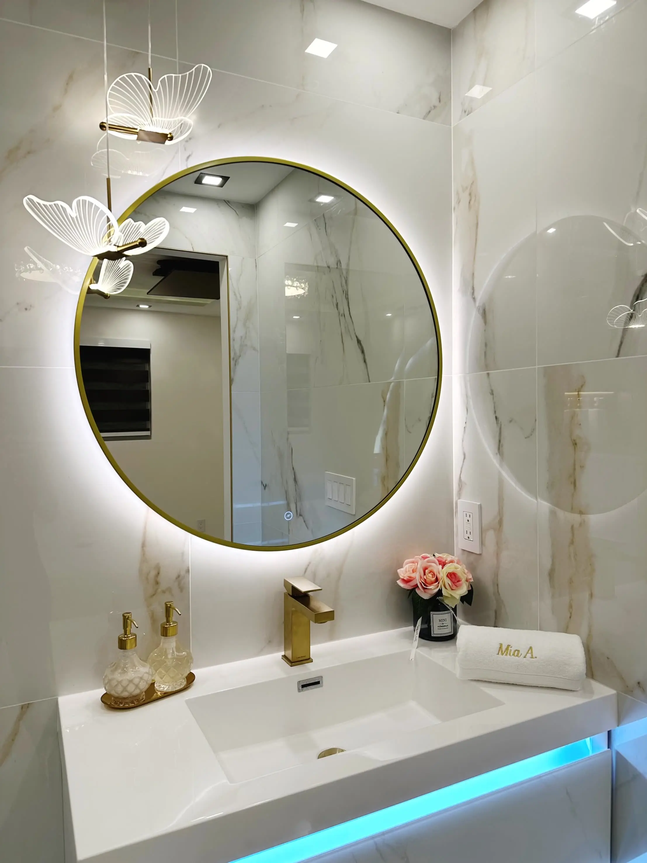 Bright marble bathroom mirror with LED backlighting, modern gold fixtures, and stylish decor.