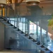 Glass staircase with sleek metal handrail and glass panels in modern building.