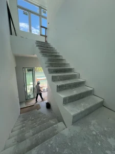High-quality glass staircase in a modern home under construction, showcasing sleek design and clear glass panels.