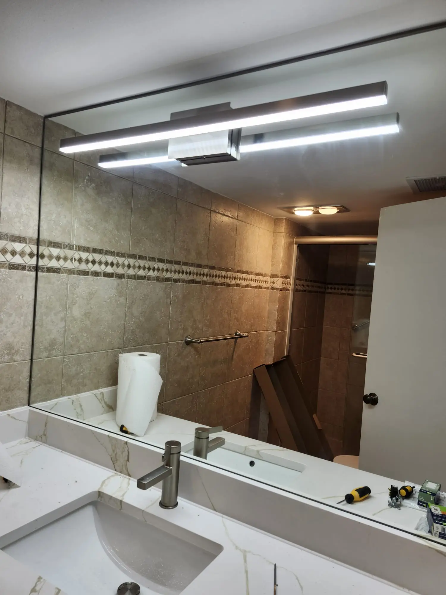 High-quality custom mirror installation in a modern bathroom setting with sleek lighting.