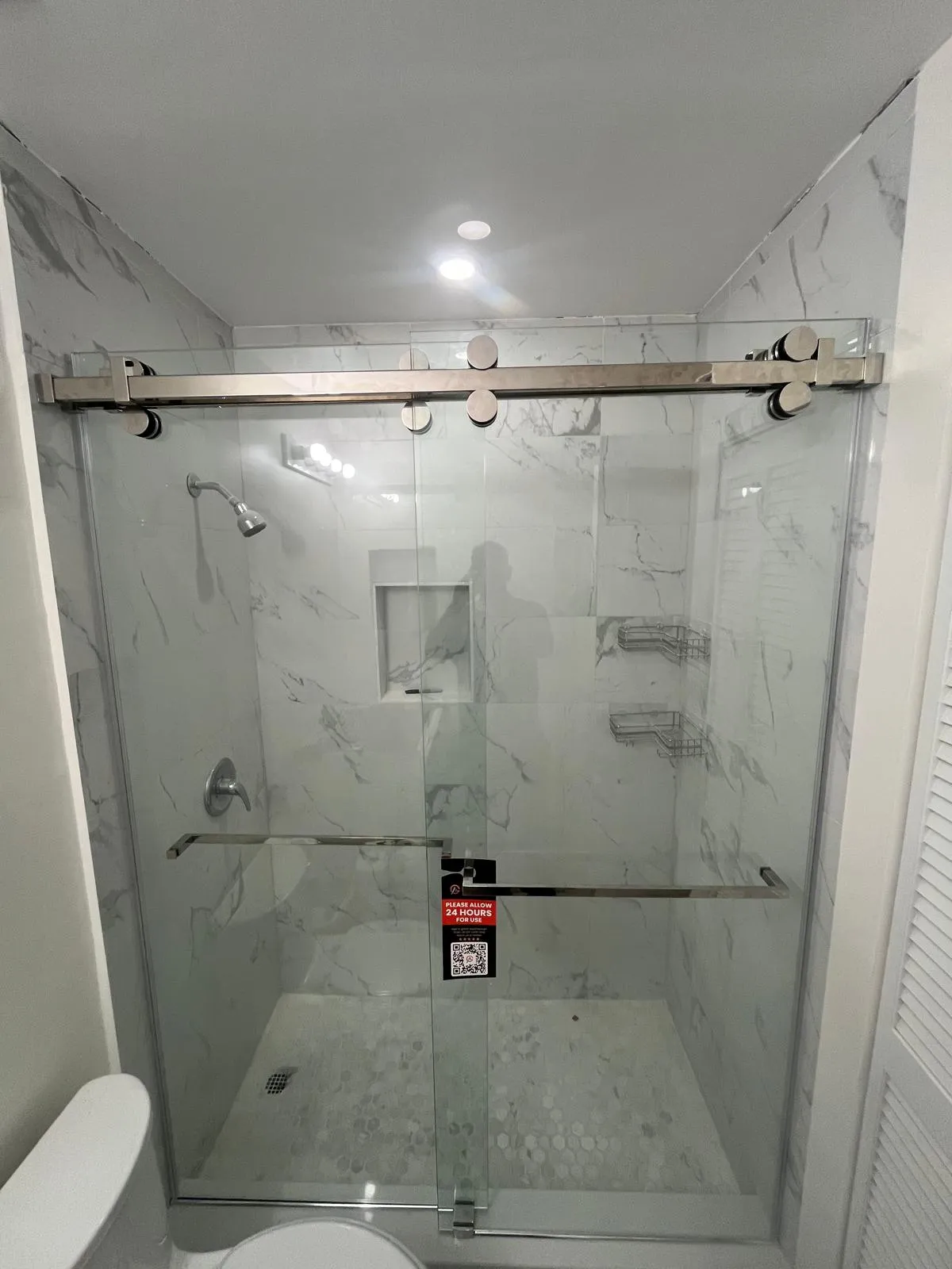 Elegant glass shower with brushed metal sliding door. Modern, durable, and stylish bathroom upgrade.