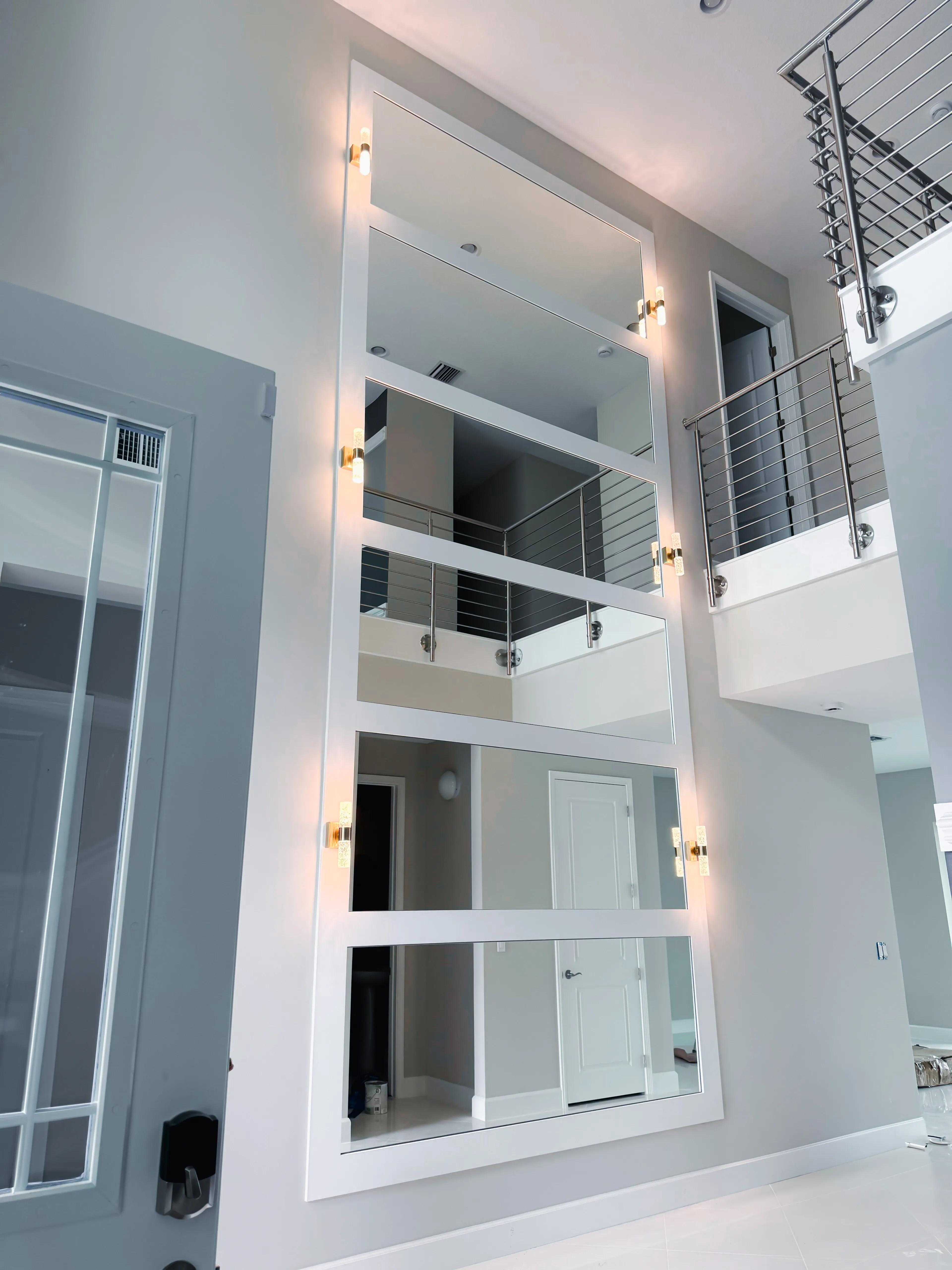 Large decorative mirror wall with multiple panels enhancing modern interior design.