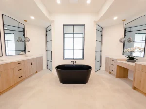 Luxury bathroom with black freestanding bathtub, sleek mirrors, and wooden cabinetry.