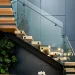 Stunning glass staircase with wooden treads and sleek glass balustrade in contemporary interior.