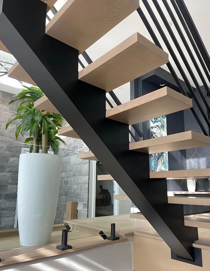 Modern glass staircase with wooden treads and black metal framing for home or office.