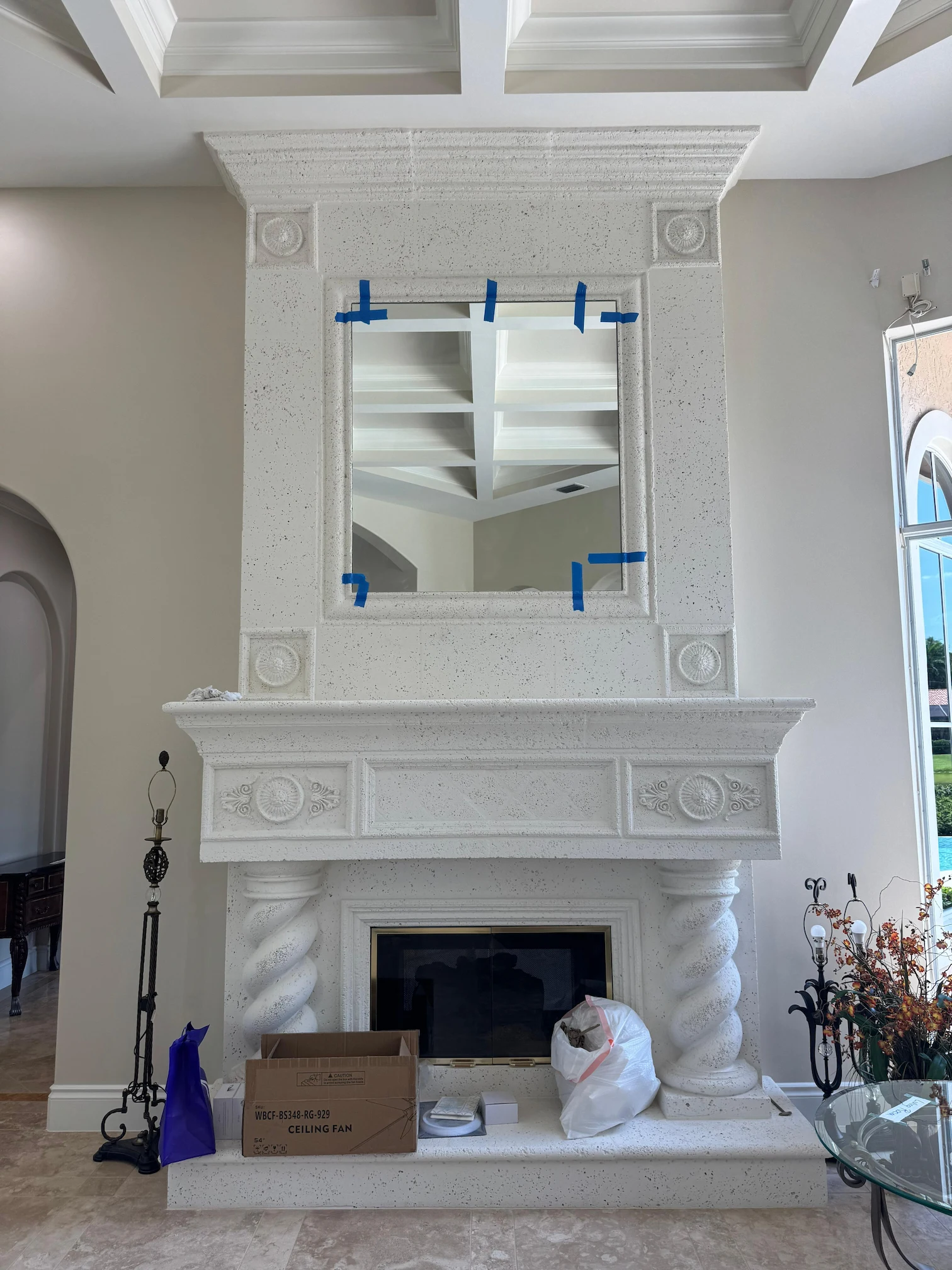 High-quality decorative mirror displayed above a classic white stone fireplace mantel. Expertly crafted for luxury interiors.