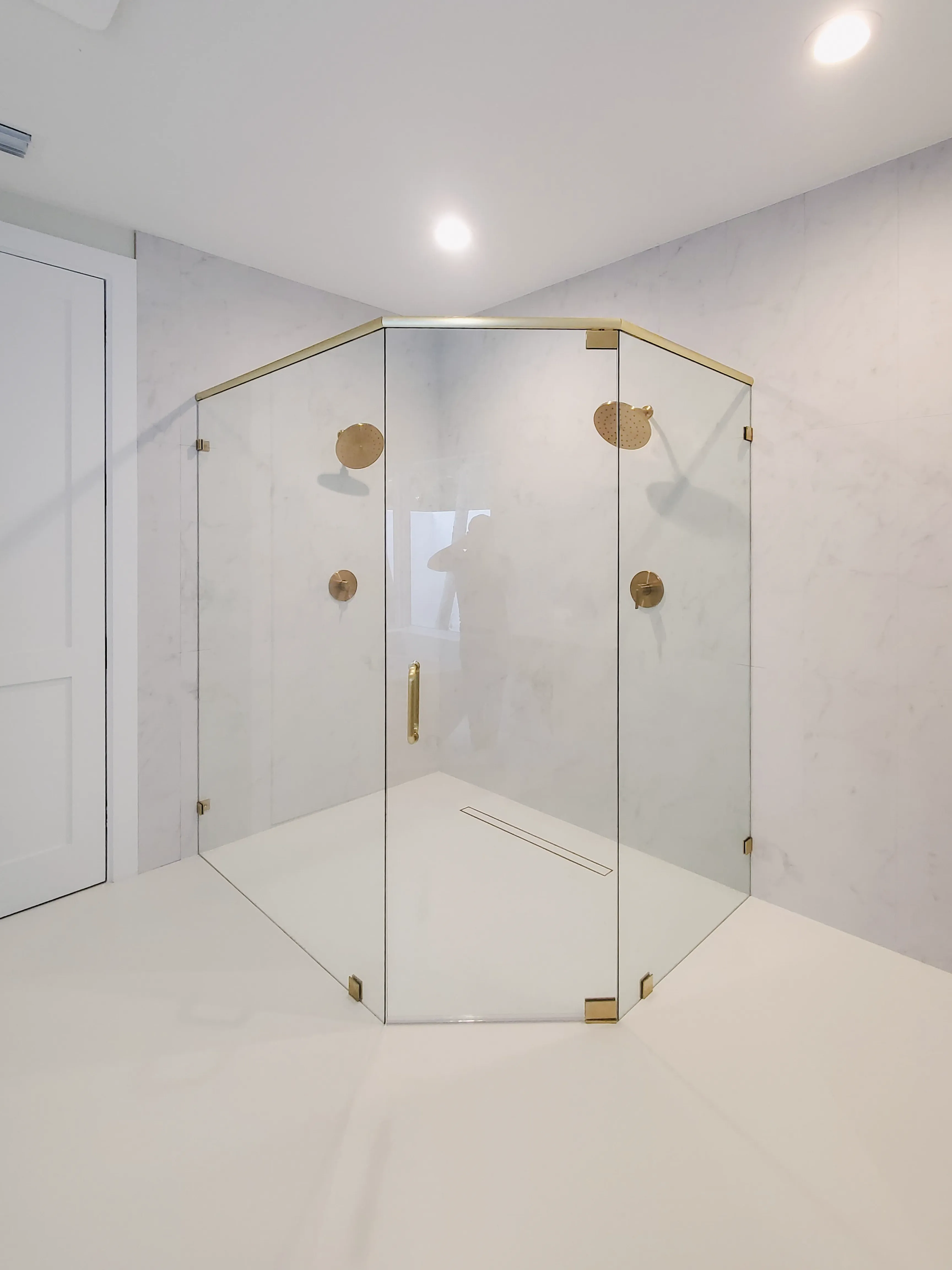 Custom glass shower with brass accents and clear panels for a modern bathroom look.