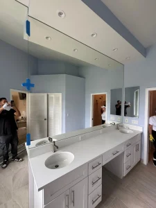 Bright bathroom mirror with double sink and contemporary vanity setup.