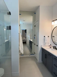 Upgraded modern bathroom with large mirror and sleek vanity for a contemporary look.