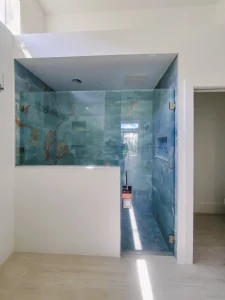 High-quality glass shower door with sleek hardware and blue marble interior for modern bathrooms.