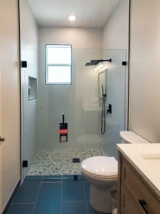 Clear glass shower enclosure with black hardware for bathroom elegance.