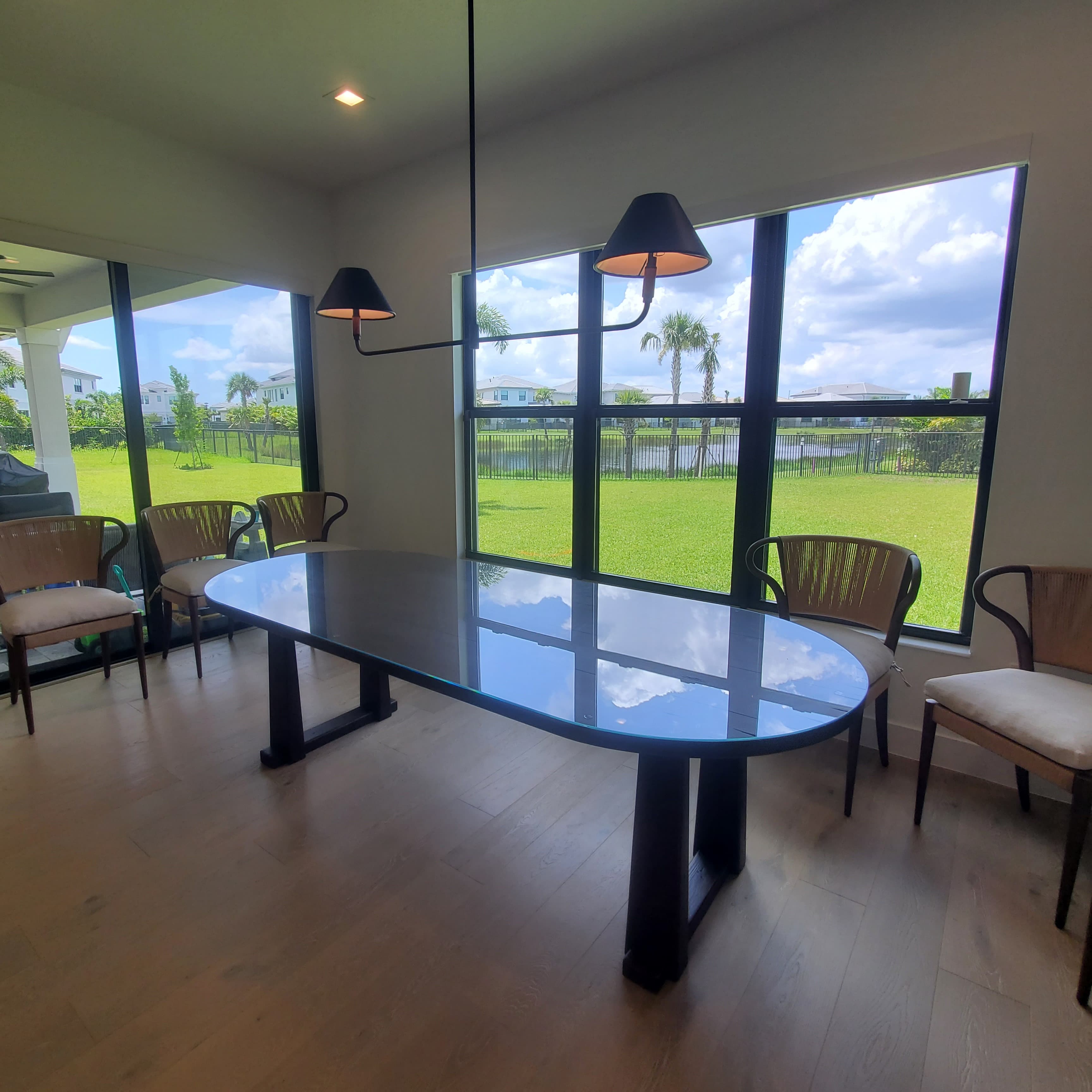 Sharp, clear glass dining table perfect for modern homes, with stylish wooden chairs and ample natural light.
