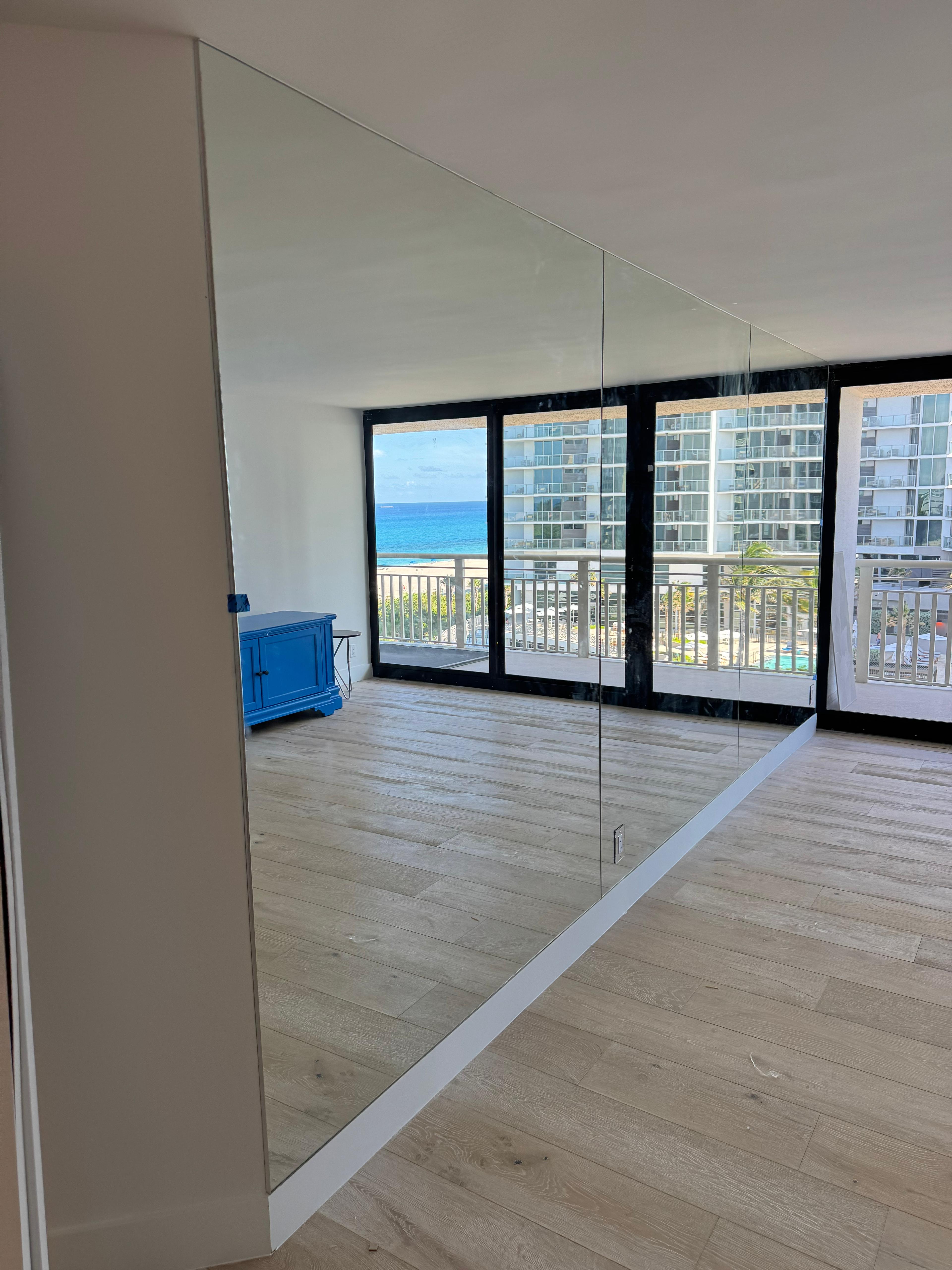 High-quality glass mirror installation for modern interiors with ocean views.