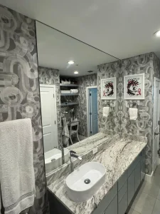 Reflective bathroom mirror with sleek glass vanity and modern decor.