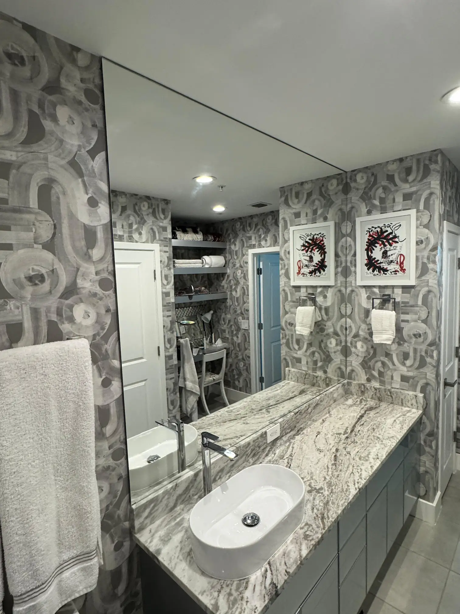Reflective bathroom mirror with sleek glass vanity and modern decor.