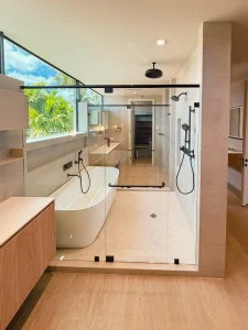 High-quality glass shower door with black hardware in a modern bathroom setting.