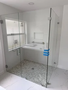 Clear glass shower door with sleek hinges, frameless design, and pebble floor tiles for luxury bathroom appeal.