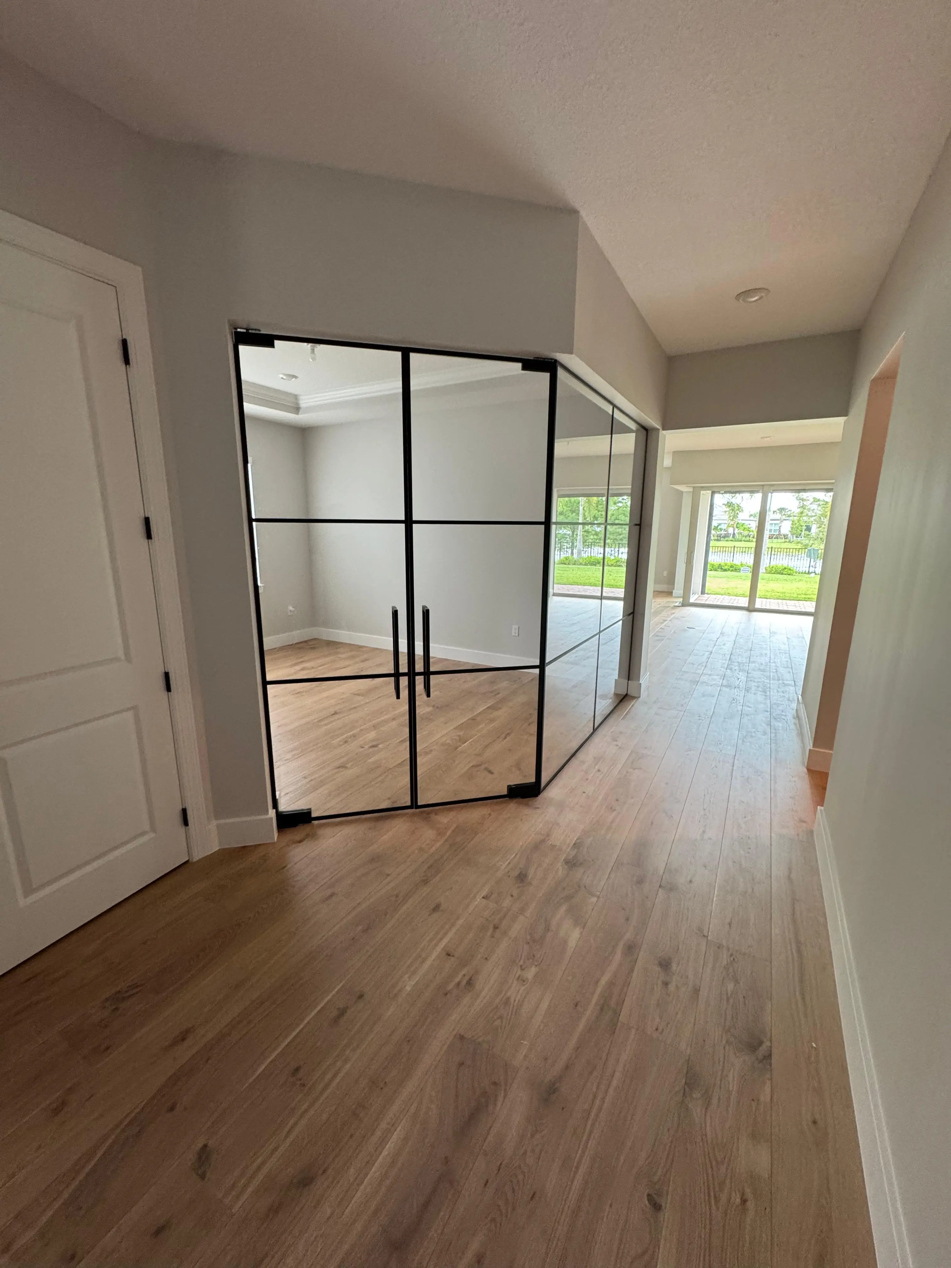 Modern glass partition with black frames in a stylish interior, enhancing space and aesthetics.