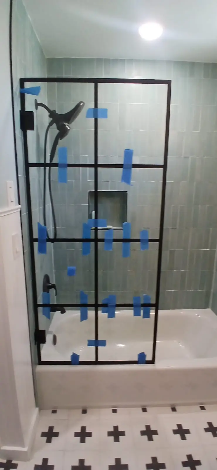 High-quality glass shower door with black frame and built-in niche, providing a modern bathroom upgrade.